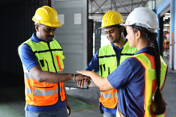 Group of engineer or worker in protective suit with hardhat standing and stacking hands celebrate successful together or completed deal commitment at heavy industry manufacturing factory or warehouse