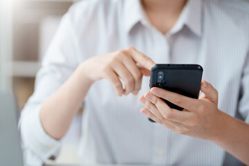 Close-up of a woman using a smartphone to work on various social media applications. including mobile transactions and LINE messaging and other business information via LINE.