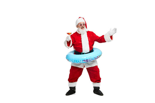 Portrait of senior man in image of Santa Claus with swimming circle and cocktail isolated over white background