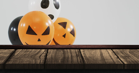 Image of halloween text over halloween balloons on wooden background