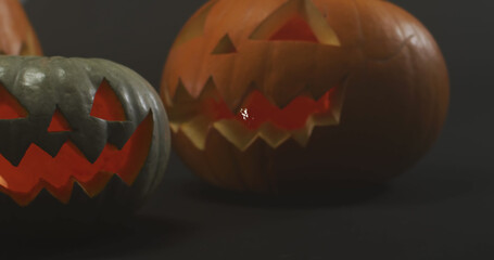 Obraz premium Image of halloween text over carved pumpkins on grey background