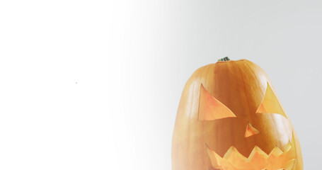 Naklejka premium Image of halloween text over carved pumpkin on grey background