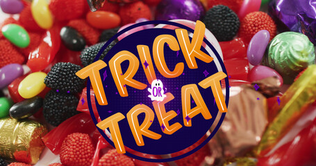 Naklejka premium Image of halloween trick or treat text over sweets background