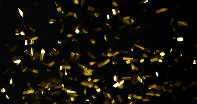Falling foil confetti with gold glitter on a black background.