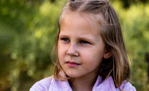 Little girl is resting in the park. Copy space. Portrait of a pretty cute girl close-up.
