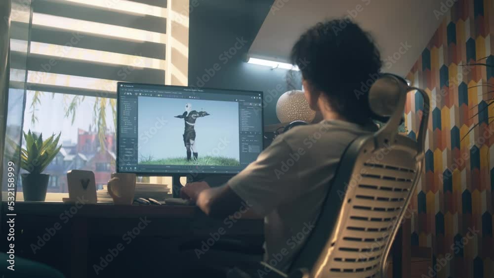Poster male 3d designer sitting at the table at home and making animation for video game character, using m