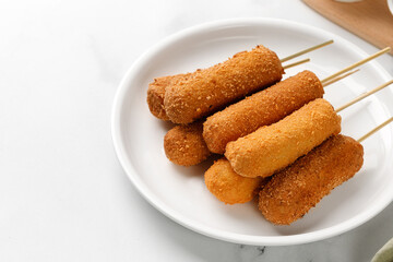 Сorn dog, corndog. Traditional American street food. Fried sausage on a stick. Homemade corn dogs on a white plate. Copy space.