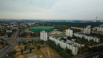 Building a stadium in a big city. Construction site among urban areas. Aerial photography.