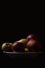 Fototapeta na wymiar Apples in a plate on a dark background.