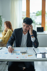 Portrait of a male businessman showing anxiety about making big investments to manage risks in the event of a marketing plan failure, taking financial and investment budget documents to working