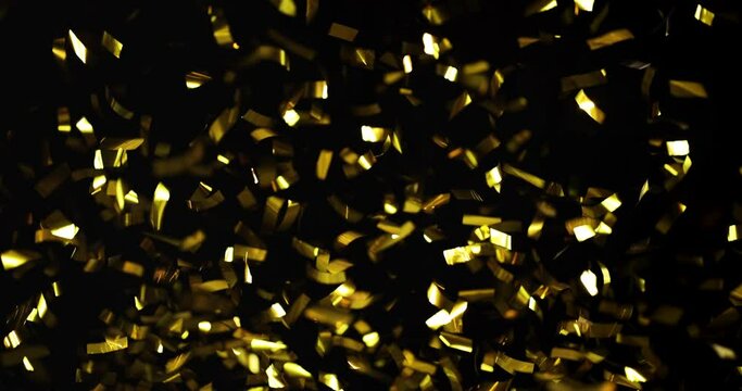 Falling foil confetti with gold glitter on a black background.