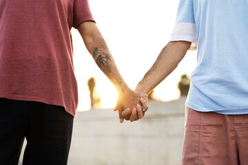 Gay couple walking together. Two man holding hands at the street.