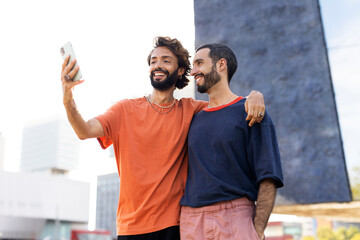 Gay couple embracing and showing their love. Men taking selfie photo.