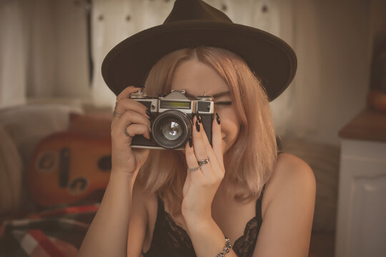 Young amateur photographer with an old camera takes pictures. Girl with a photo camera  have a good mood on a vacation
