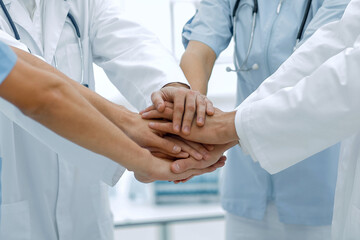doctors holding hands together at hospital