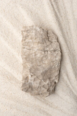 Background for cosmetic products of natural beige color. Stone podium on the sand. Top view.