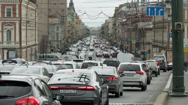 cars move slowly in traffic on a city road during rush hour