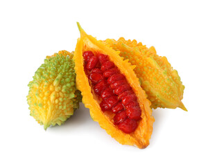 Whole and cut ripe bitter melons on white background