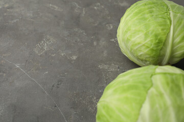 Ripe white cabbage on grey table, closeup. Space for text