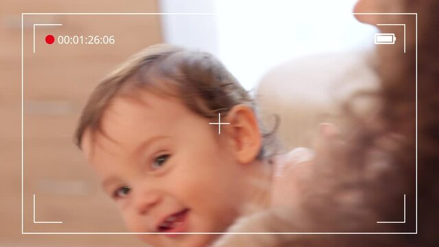 Family video recording of a mother and her baby smiling, laughing and having fun in their home. Playful, smile and happy mom holding and playing with her child in their modern and comfortable house.