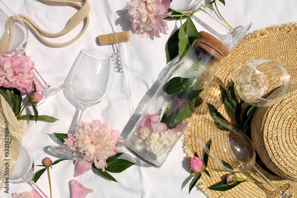 Poster Flat lay composition with beautiful peonies and wineglasses on white fabric