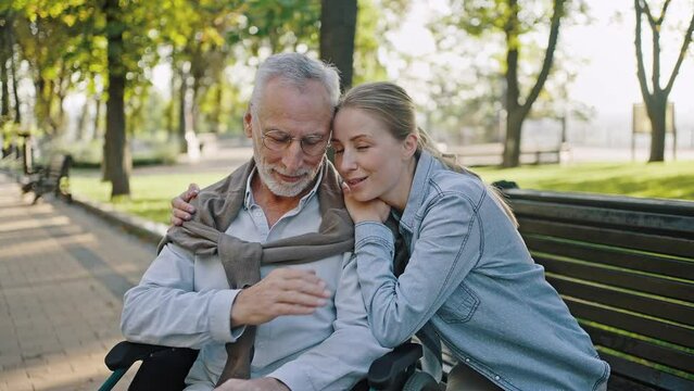 Young woman hugs disabled elderly man sharing good news