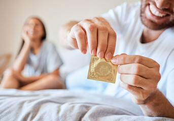 Condom, sex and safety for sexual couple in bed together happy, smile and use protection....