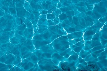 Water background, turquoise shallow sea water. Beautiful texture of sun glare on the water.