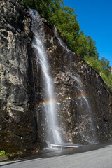 Wonderful landscapes in Norway. Vestland. Beautiful scenery of a little waterfall the Ornesvingen viewpoint from where you can take a shower. Rainbow, rocks and trees. Summer sunny day Selective focus