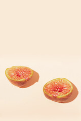 Minimal composition made with fig cut in half on bright pastel background. Fresh juicy fruit concept.
