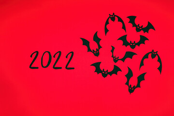 Cut out and black cardboard lie on a red background, on the left side of the frame the numbers 2022 in the right bats
