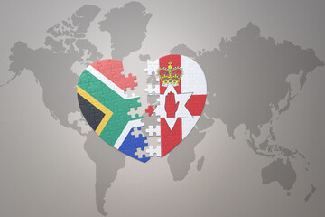 puzzle heart with the national flag of south africa and northern ireland on a world map background. 3D illustration