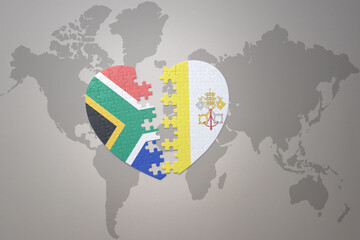 puzzle heart with the national flag of south africa and vatican city on a world map background. 3D illustration