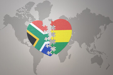 puzzle heart with the national flag of south africa and bolivia on a world map background. 3D illustration