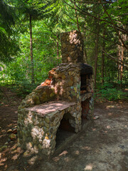 Stone oven with a chimney in the forest on a sunny day, used for outdoor cooking. Ukraine