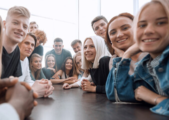 close up. a large group of friends sitting at a long table