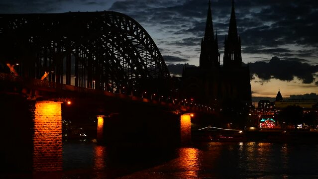 Cologne Cathedral (Koelner Dom) and Hohenzollern Bridge through Rhine river in Cologne, Germany. Low key picture