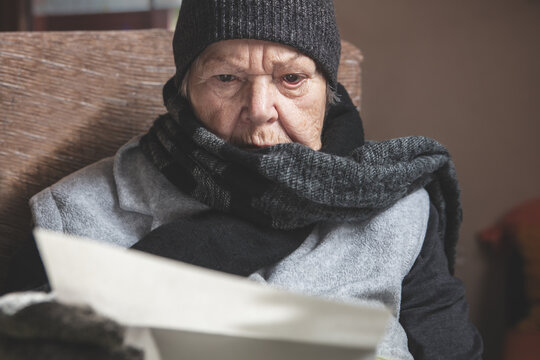 pensioner is sitting with winter clothes indoors