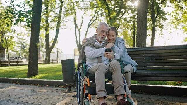 Woman enjoys watching family photos with elderly father