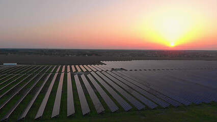 Aerial drone view into large solar panels at a solar farm at summer sunset. Solar cell power plants. footage video 4k.