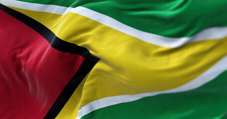 Close-up view of the Guyana national flag waving in the wind. The Co‑operative Republic of Guyana is a country on the northern mainland of South America. Fabric textured background. Selective focus