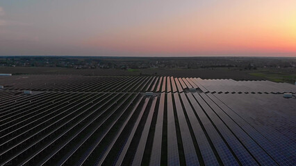 Aerial drone view into large solar panels at a solar farm at summer sunset. Solar cell power plants. footage video 4k.