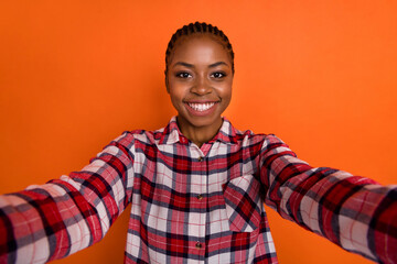 Photo of shiny cute lady wear checkered shirt recording self video isolated bright vivid orange color background