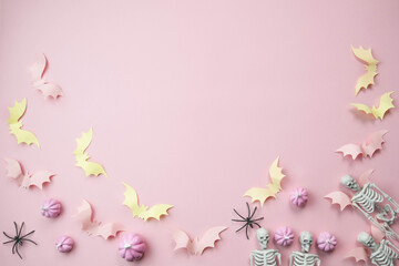 Fototapeta na wymiar pink background with a place for text with small pink pumpkins with pink bats spiders skeletons broom witches, the concept of a creative happy Halloween