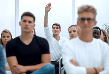 young man asks a question during a business seminar