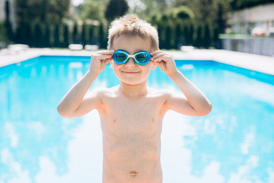 Young boy kid child eight years old near swimming pool having fun leisure activity