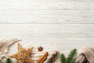 Christmas decorations concept. Top view photo of pine branches wicker star knitted plaid anise and cinnamon sticks on white wooden desk background with empty space