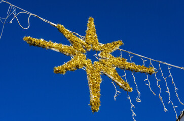 Una luminaria di natale a forma di stella gialla si staglia nel cielo azzurro di Corigliano...