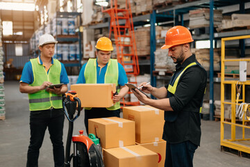 Management having discussion at warehouse with white hardhat using digital tablet Working in Logistics and Distribution Center...