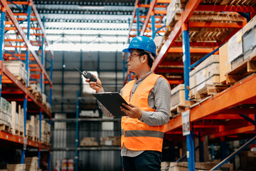 Storage worker in uniform and notepad,digital tablet in hands checks production. warehouse concept.